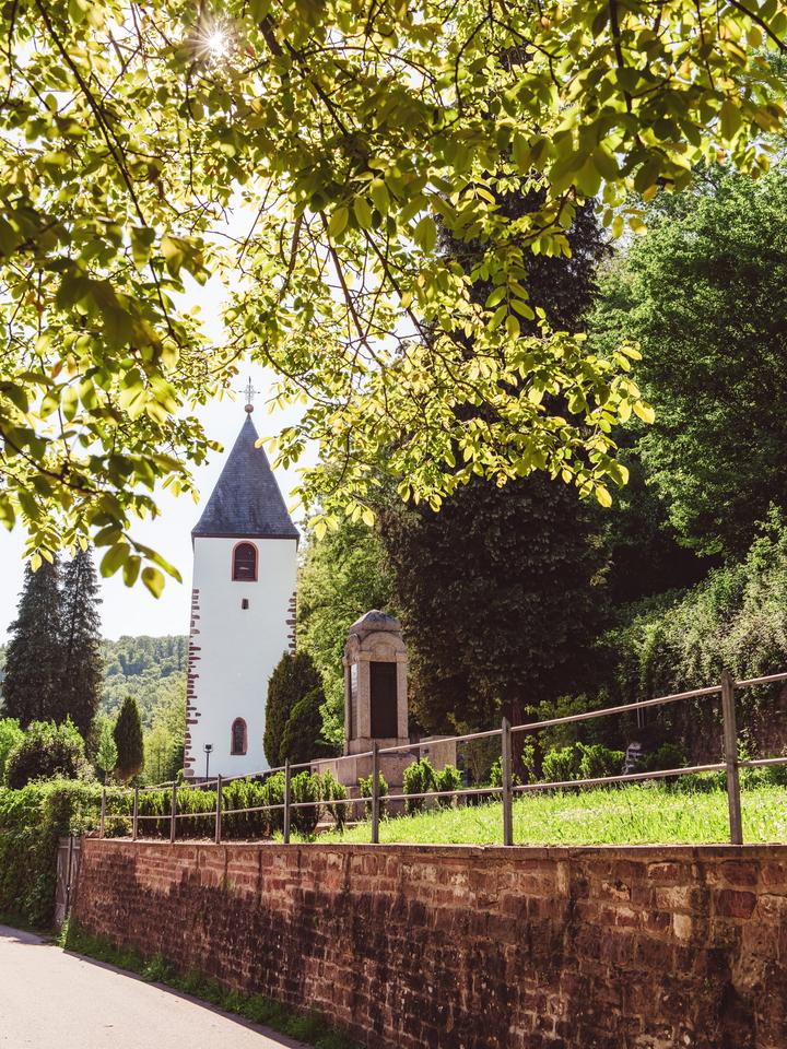 Die historische Friedhofskapelle am Kirchplatz, erbaut im 19. Jahrhundert und flankiert vom Alten Turm.