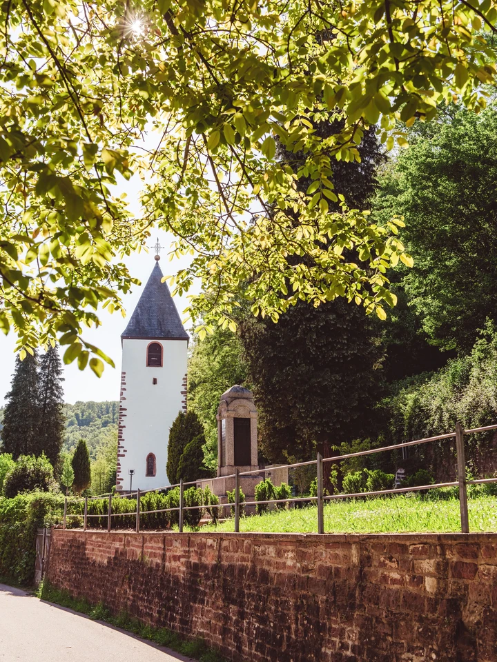 Die historische Friedhofskapelle am Kirchplatz, erbaut im 19. Jahrhundert und flankiert vom Alten Turm.