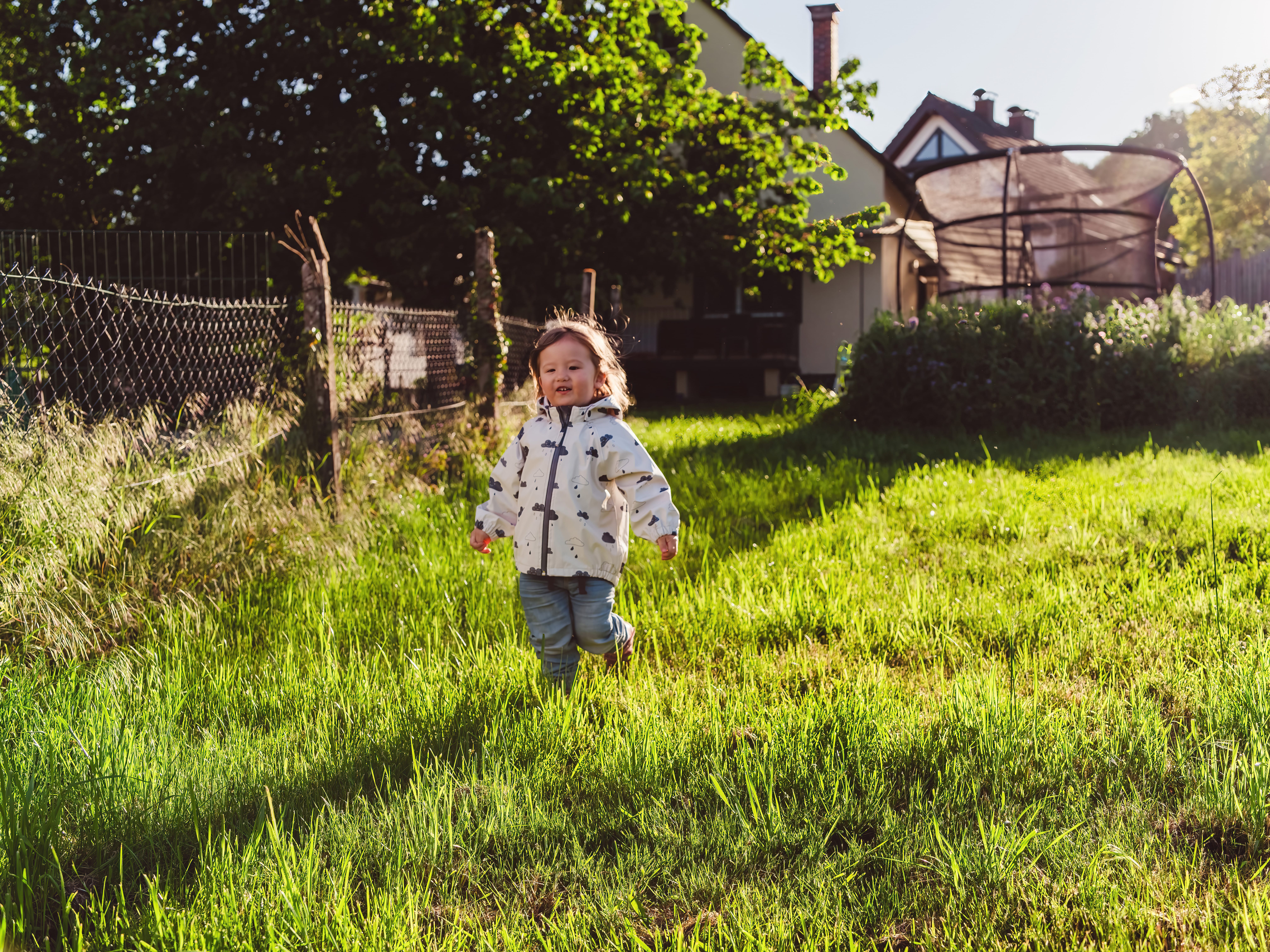 Ein fröhliches Kind tobt im Frühlingsrasen – Symbol für unbeschwerte Familienmomente in Bammental.