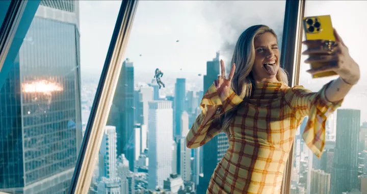 Superman (2025): Selfie in Wolkenkratzer-Office, dahinter Luftkampf und Rauch über der Skyline – Social-Media-Satire im modernen DC-Superheldenfilm